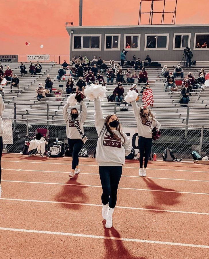 Silver Creek athletes cheer at a recent football game. In this photo Willow Martinez (senior), Bridget Hauger (junior), and Emma Reiner (freshmen) are cheering on their Raptor football players to victory. This football season was the very last and very first for some Silver Creek cheerleaders.