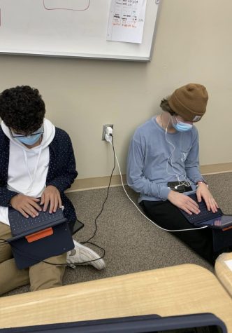 Two students working hard while wearing masks in a Boulder County school.