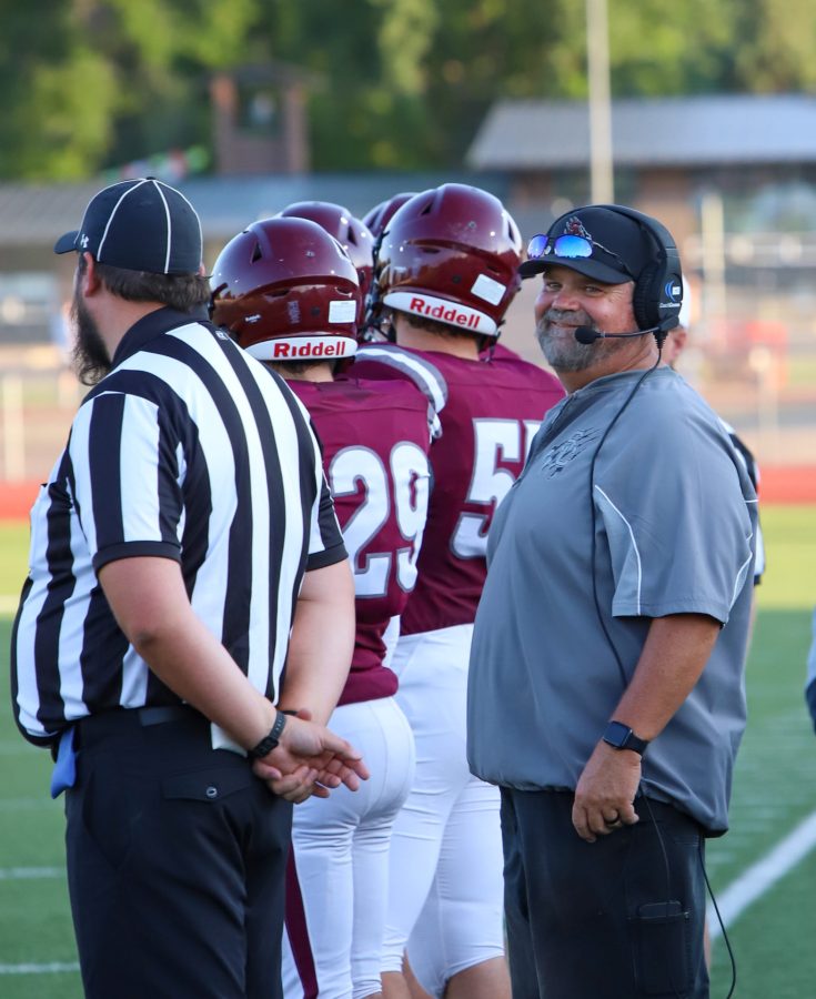 During the first Football game of the 2022 season, head coach Brian Mcgee cracks a smile as his captains are about to walk up for the coin toss.