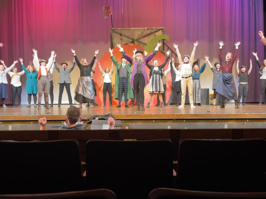 The ending scene of the school produced musical James and The Giant Peach where students all gather on stage to bow. Students names from left to right are:  Back row: Noor Denolf, Echo Bostic,  Erin Davis, Addison Brents, R.C. Bader, Adelei LaConte, Rowan Tiner, Allison Heydt, Rune Denolf, Elsa Wirkkanen, Grace Ann Dunn, Mink Goodwin, and Miisa Tuuri. Front Row: Ollie O’Brien, N Legg, Gavin McIntire, Tracker Rose Legg, Kameron Ruth, and Banjo Tingstad. Front: Averi Adair.