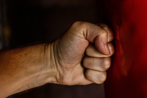 Human fist hitting a wall showing violence.