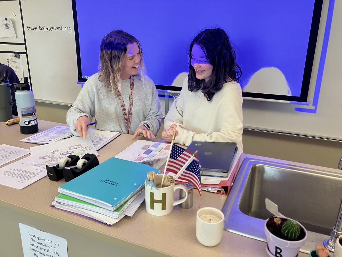 Silver Creek High School teacher Kristen Brown and senior and current Instructional Student Assistant Olivia Stratton discussing teaching techniques after an I.S.A meeting.