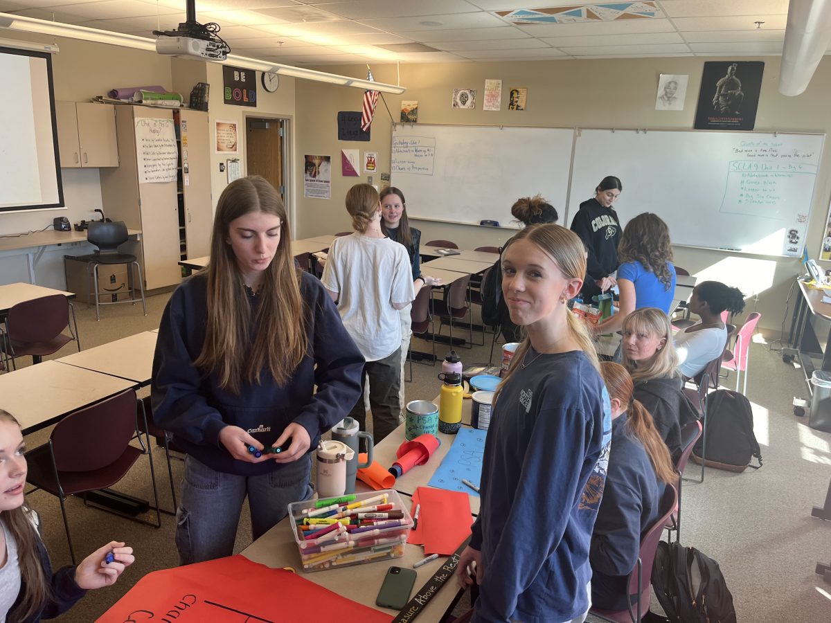 Silver Creek Students and Peace and Service for Africa members Jacqueline  Jarvis and Lily Hensley working on posters for their annual Change for Change fundraiser.