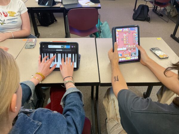 Robert Codron and Anna Goodbee playing Cat Snack Bar and The Piano on their IPad instead of working during class