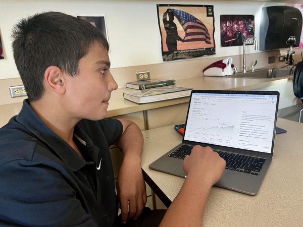 Wais Ezzat working on a PFL assignment about the Stock Market in David Speckl’s class. 