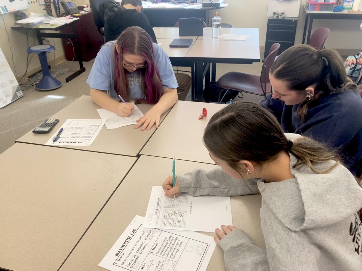 From the left: Lola Allen, Mia Kunio, and Rachel Brett collaborating on a worksheet in Kay Van Danacker’s Honors Geometry class.