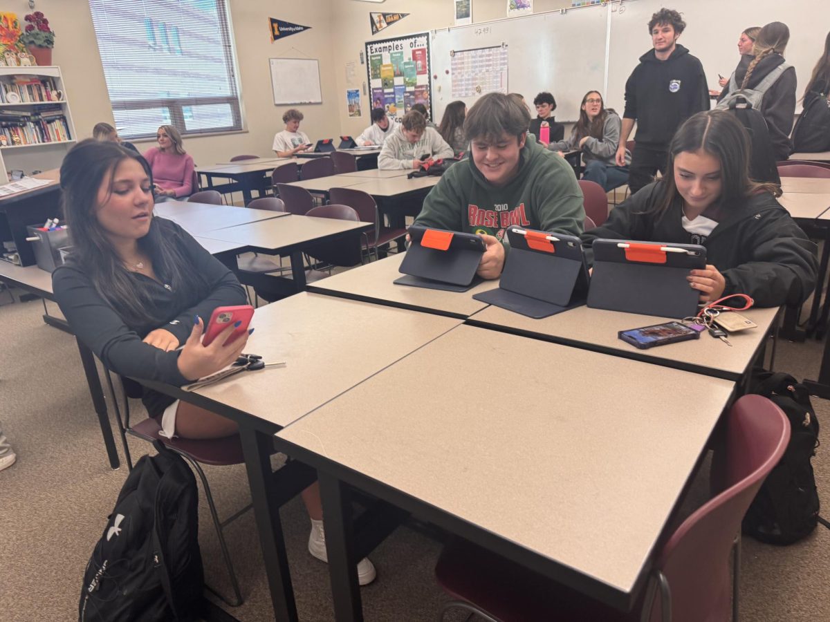 Students in yearbook working on their latest page for the yearbook class. On the right Josie Starks, in the middle Hudson Mehren, on the left Phoebe Richmond.