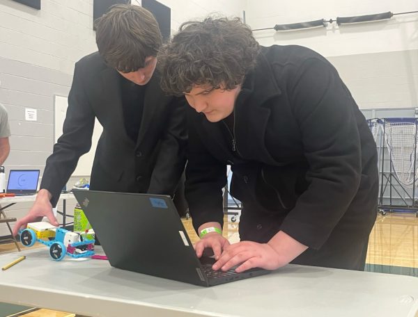 Members of the Silver Creek High School Science Olympiad team Apollo Johnson (left) and Ethan Gregory (right) are at Fossil Ridge High School working on their electric car during the competition on March 1, 2025.