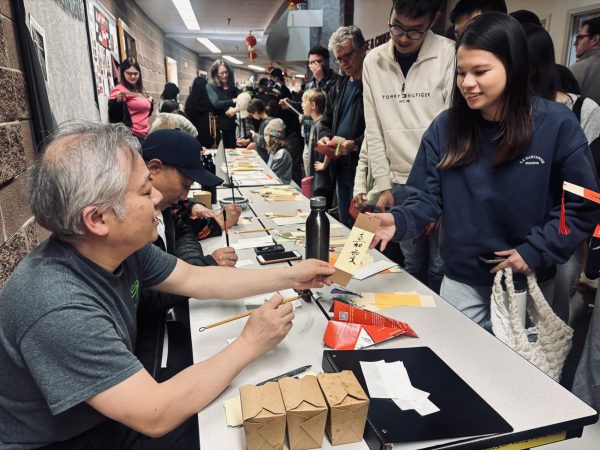 Volunteers in the Longmont community transcribe names of community attendees on bookmarks at the Silver Creek High School, Lunar New Year event, 2025.