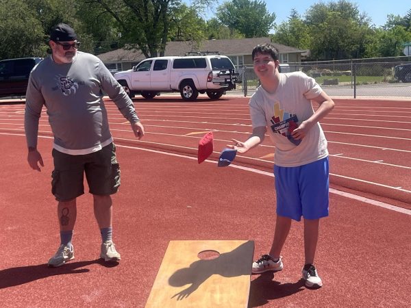 Nathan Anderson, Silver Creek sophomore, plays Corn Hole at Day of Champions while Chris Blair cheers him on. The Day of Champions allows for special education students to participate in athletic events and activity’s.